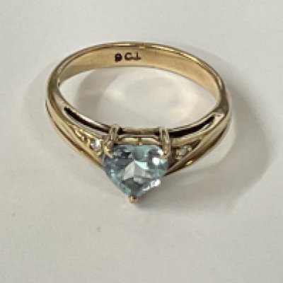 9ct yellow gold ring set with a heart shaped topaz flanked by diamonds. Topaz 0.50ct approx. Diamonds 0.02ct approx. Ring size approx I/J. Postage category A.