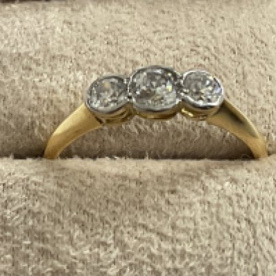 18ct yellow gold graduated RBC diamond rub over set trilogy ring with stylish box. Diamonds 0.45ct. Ring size approx K. Postage category A.