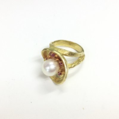 A yellow metal ruby and pearl set ring, tested 18ct yellow gold, size I 1/2. Approx weight 9.25 grams.