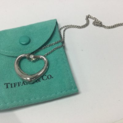 A silver Tiffany & Co pendant inset with a single diamond stone. Postage category A