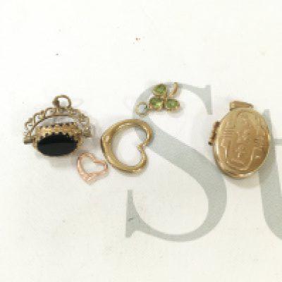A small collection of 9ct gold charms, fobs and lockets.