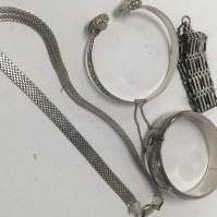 Two silver bangles a silver necklace and a silver gate bracelet.