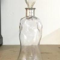 A glass decanter with a hallmarked silver rim, London 1918. 28cm tall. This lot cannot be posted