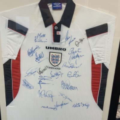 England 1998 Framed Signed Football Shirt: Squad signed to front. Includes Shearer Merson Clemence Southgate James Beckham and Le Tissier,  in fact 19 autographs in total. Frame measures approximately 42 inches by 32 inches. No COA. Not for posting. 
