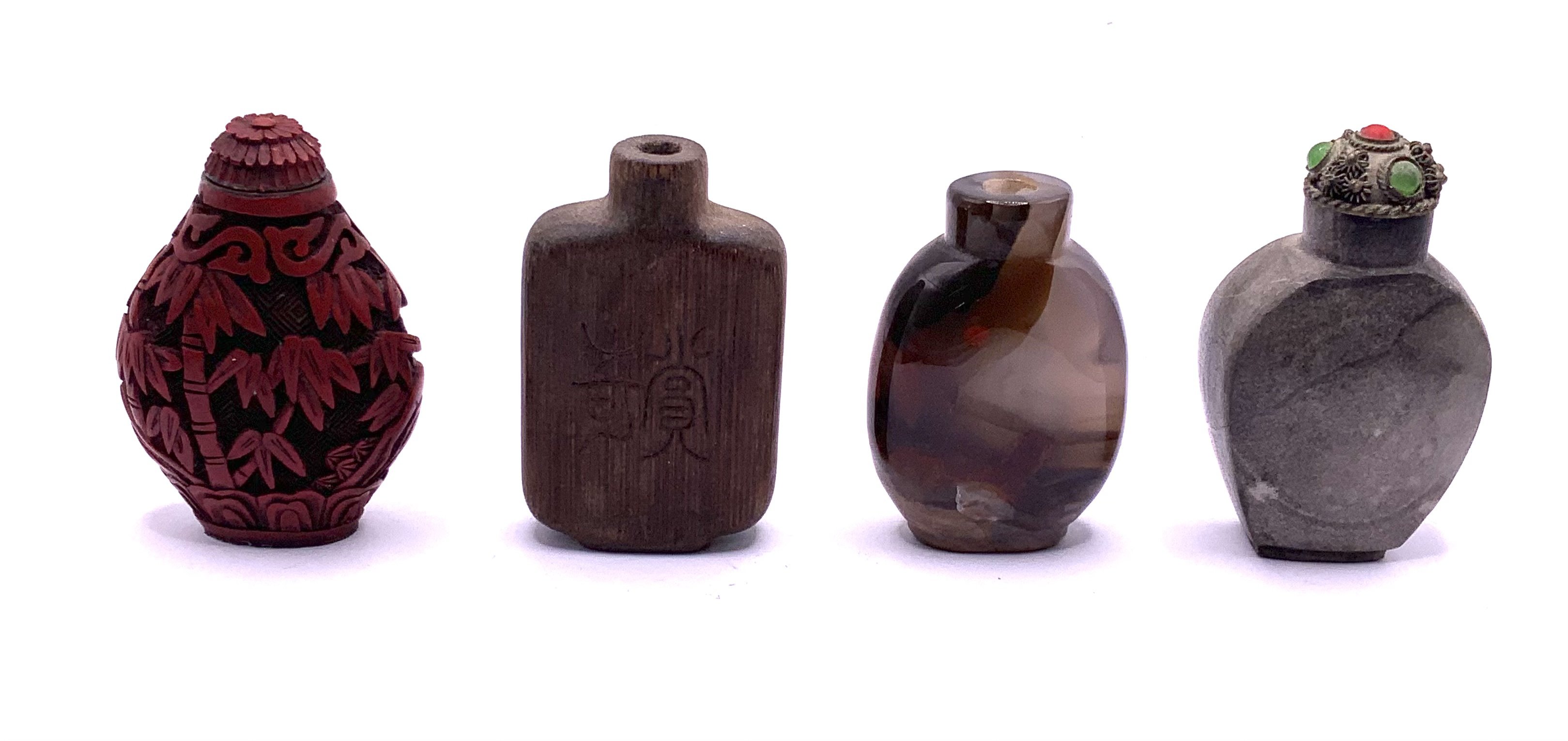 4 good early 20thC Chinese snuff bottles to include a Cinnabar lacquered example, Carved bamboo, Polished agate, polished stone. 5cm.