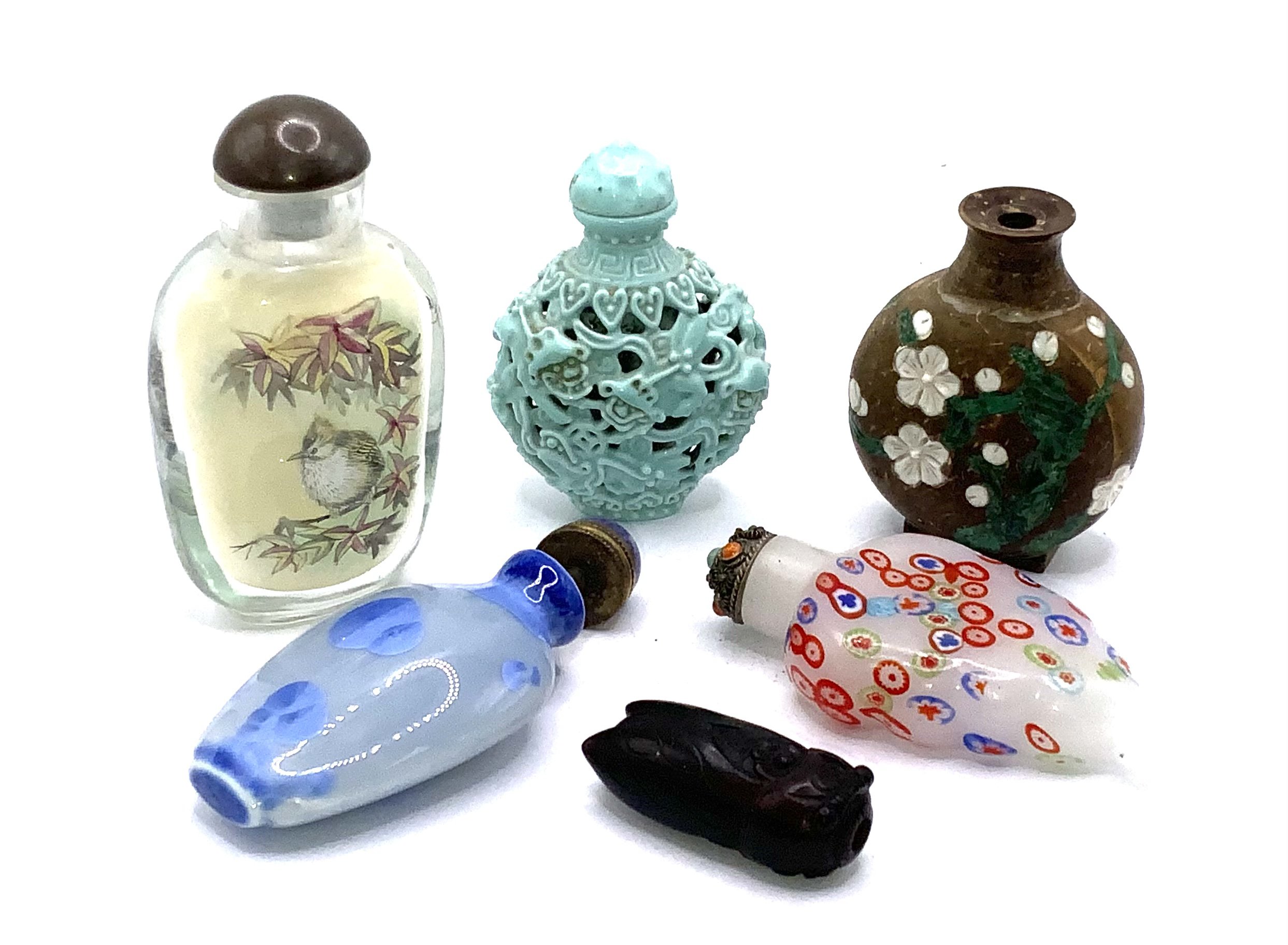 A small collection of snuff bottles to include small millefiori glass example, Inside painted example, Turquoise porcelain pierced example, Reconstituted coconut shell inset with malachite, porcelain bottle with virus glaze, and a small amethyst glass cicada .snuff bottle.