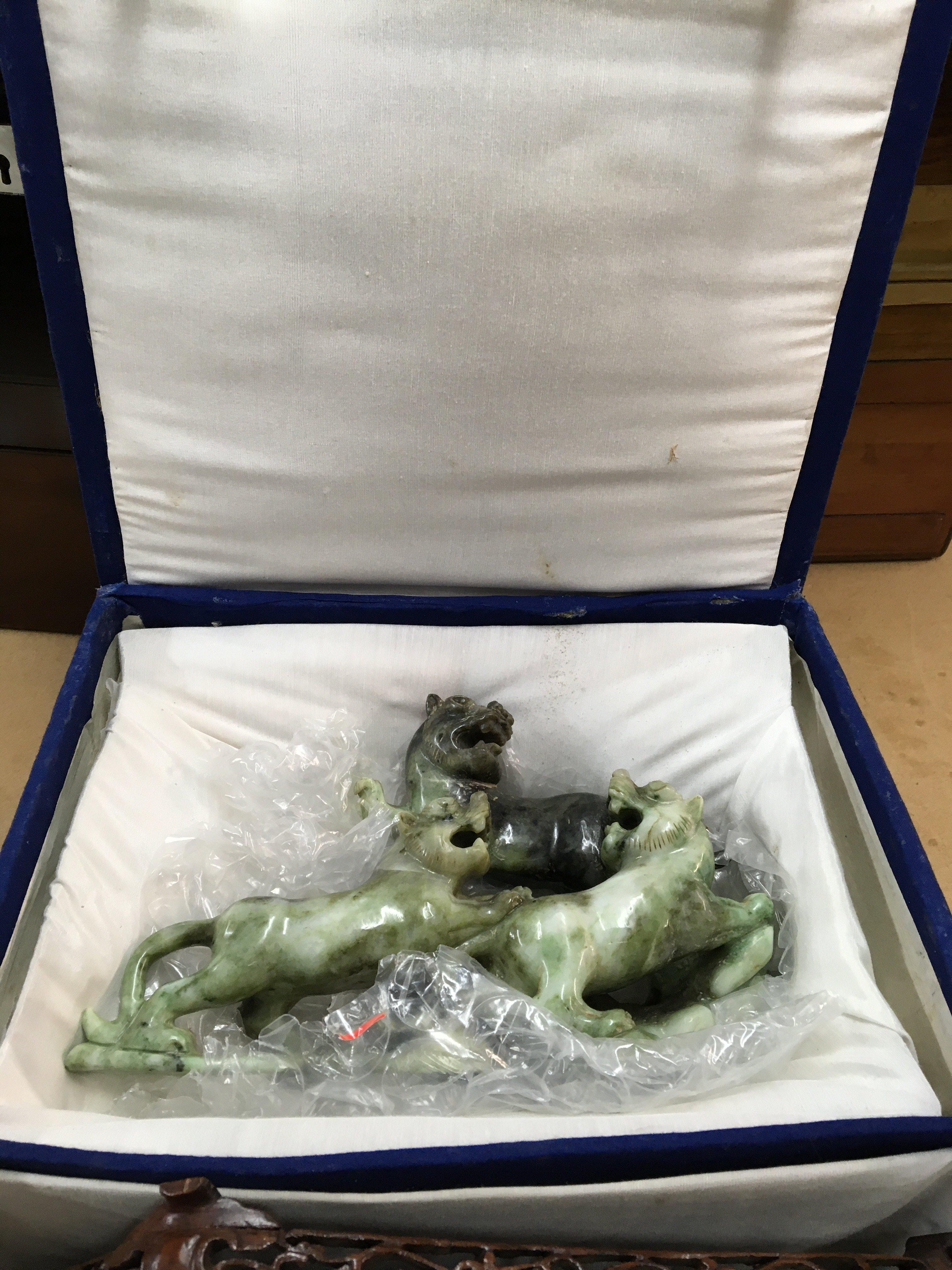 A boxed and carved Oriental soap stone figure of a Dog of Foo, with carved wooden stand