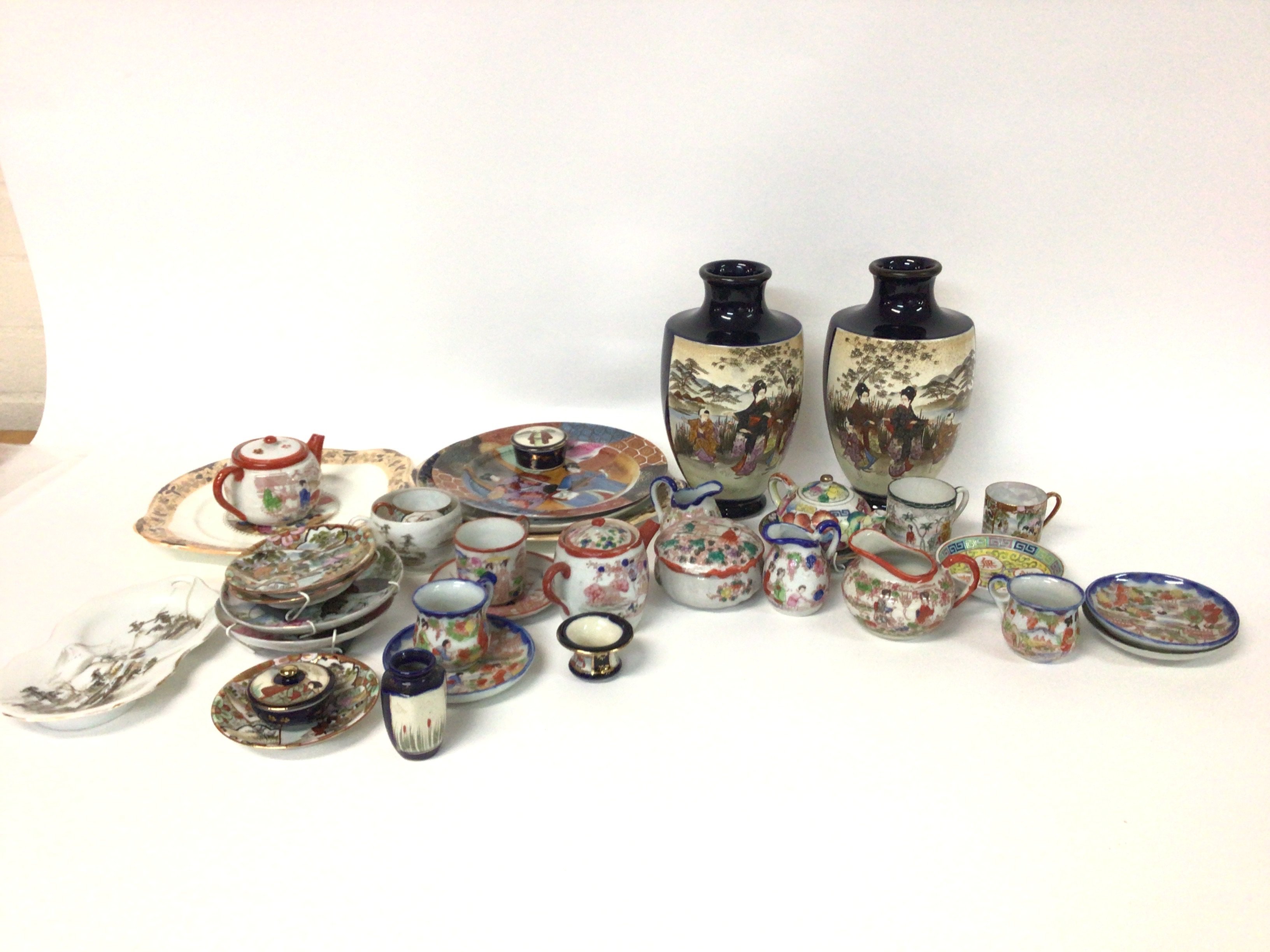 A pair of Japanese satsuma vases, cups and saucers. Postage category D