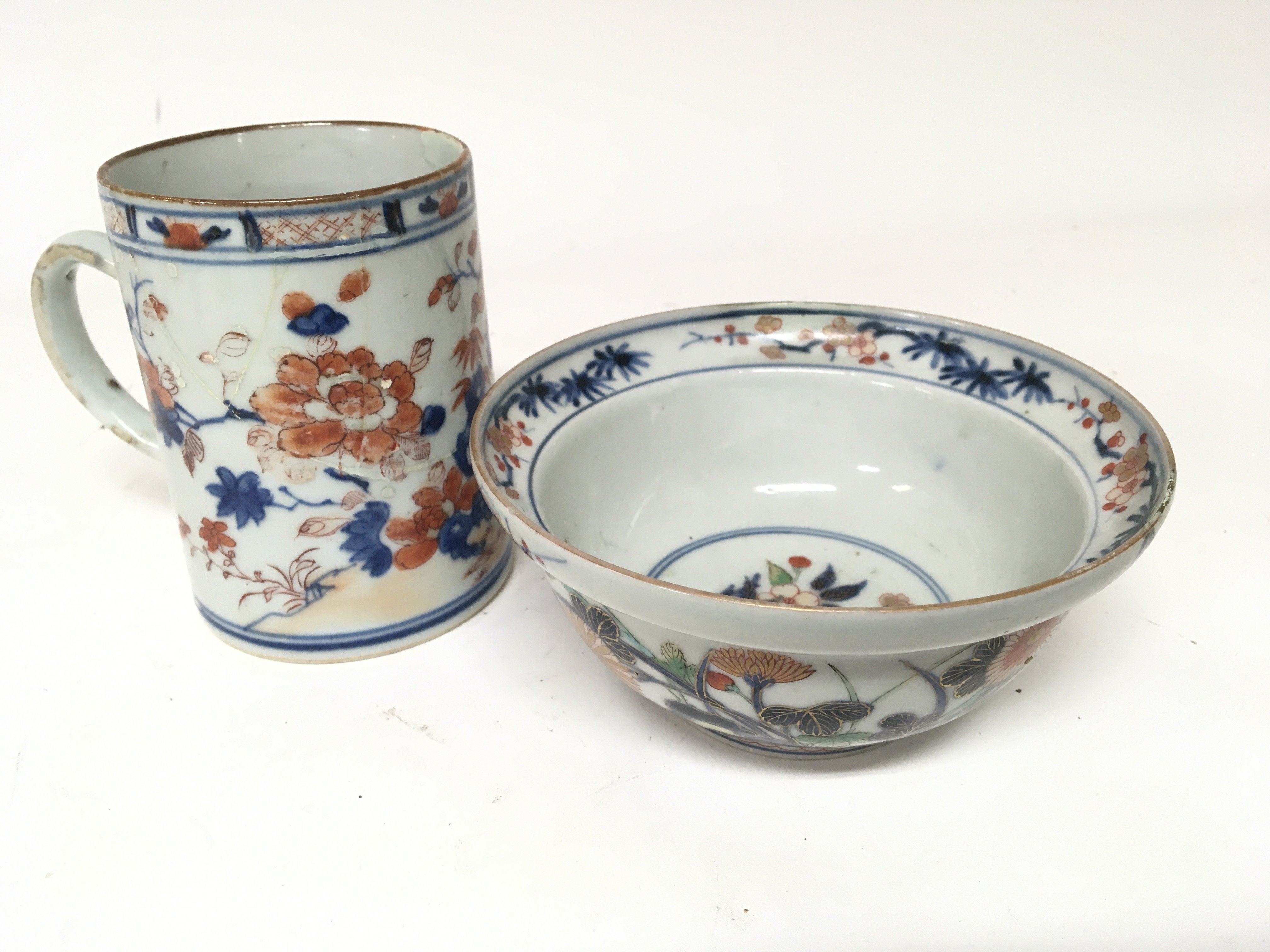 Two examples of genuine 18th century Chinese Export porcelain a mug and a bowl the bowl with an Imari type patter both damaged and with restoration height 12cm diameter of the bowl 15cm (2)