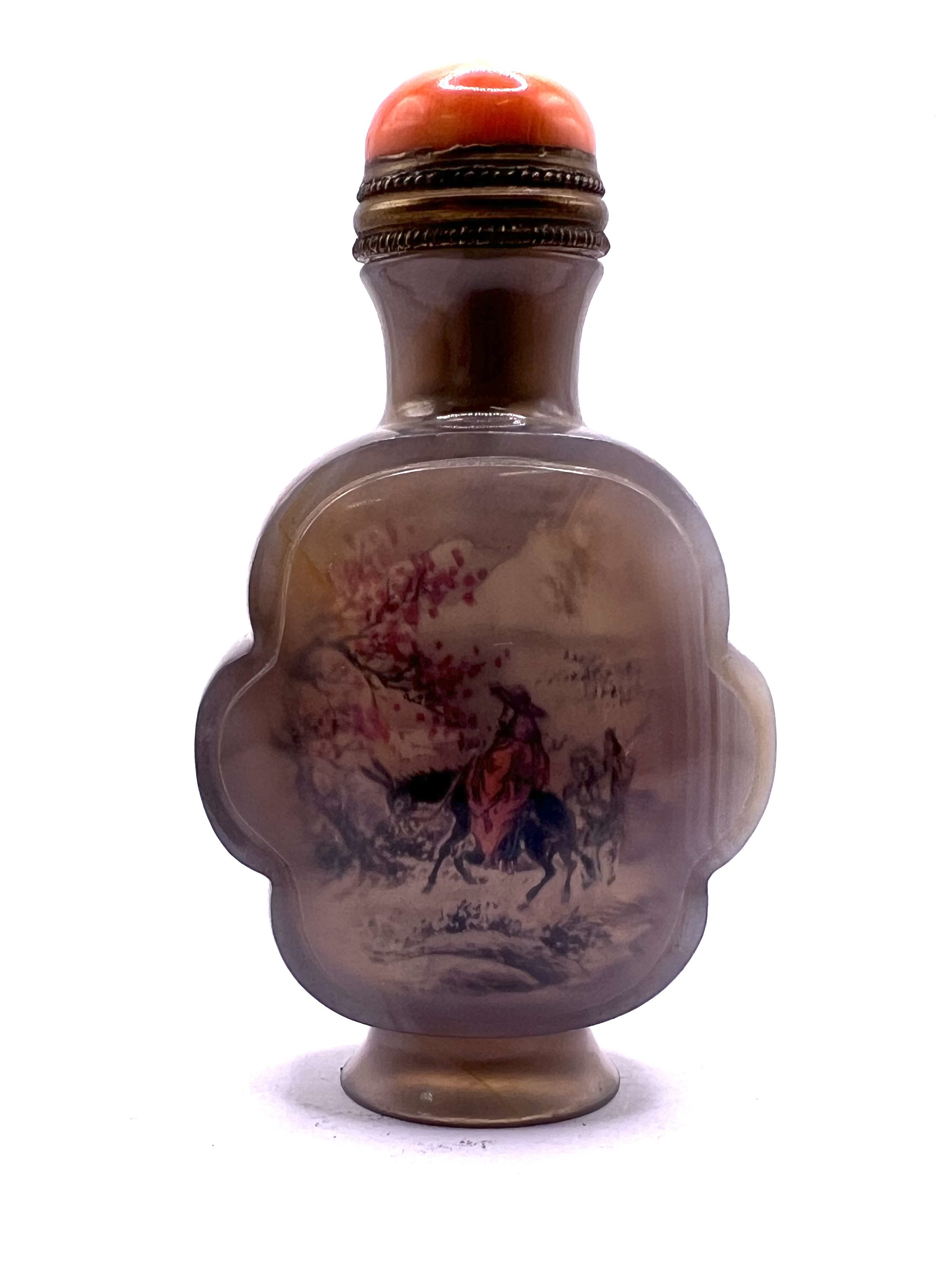 A finely carved and polished inside painted agate snuff bottle in cloud form, with brass mounted coral stopper. 8cm.
