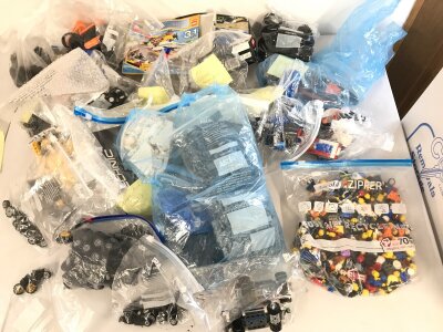 A large collection of loose Lego sets some with corresponding boxes.