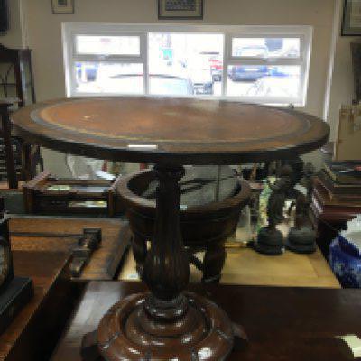 A Victorian mahogany occasional table the circular top with tooled leather inset on a flutted column and round base. NO RESERVE