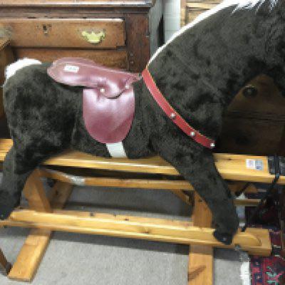 A fabric and wood rocking horse on a pine base. NO RESERVE
