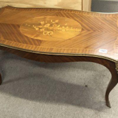 A French style inlaid walnut occasional table with a shaped top and floral motif with applied gilt metal mounts.