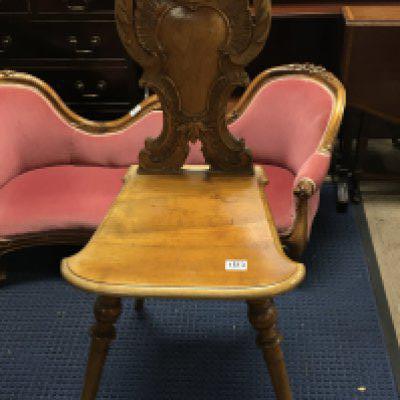 A Continental carved hall chair with a carved back solid seat and turned legs. NO RESERVE