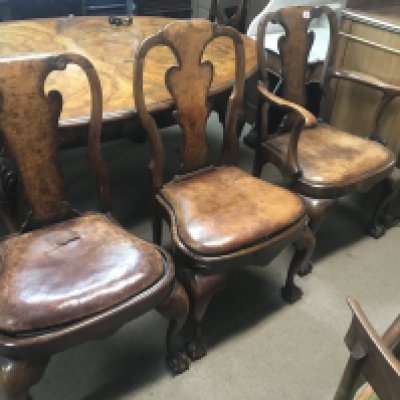 A walnut dining table with extra leaf together with a set of eight chairs including two carvers .