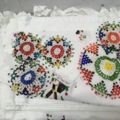 A collection of embroidered linen and lace tablecloths from Mauritius, 12 seater with matching napkins, centrepiece and additional linen. Postage category B- NO RESERVE