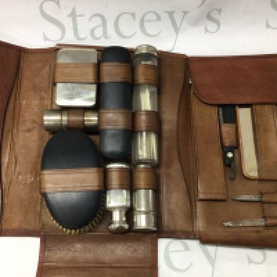 A vanity case containing glass jars, brush, razor etc together with a silver hand mirror