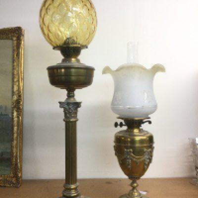 Two oil lamps comprising a Corinthian column example and one with decorative swags. Shipping category D.