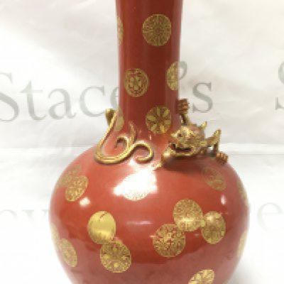 A 20th Century Chinese coral ground bottle vase with gilt decoration roundels and shou medallions and dragon figure , four character mark at base. 33cm tall. No obvious damage or restoration This lot cannot be posted