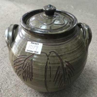 A jar and cover with raised side handles, dark green glaze incised decoration and impressed potters mark. 250cm. NO RESERVE