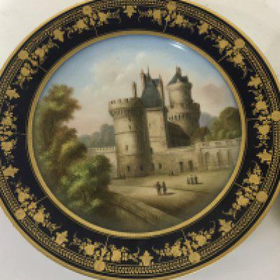 A Sevres porcelain hand painted cabinet plate a view of a chateau marks to the reverse some minor restoration and a hand painted porcelain plaque depicting a courting couple in 18th century dress in an oval gilt frame (2) NO RESERVE