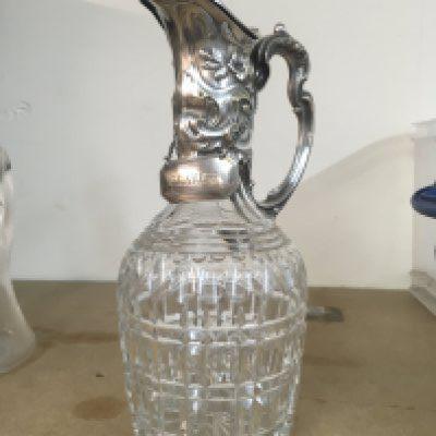 A very ornate Victorian cut glass decanter with embossed decoration and handle and with claret label. This lot cannot be posted