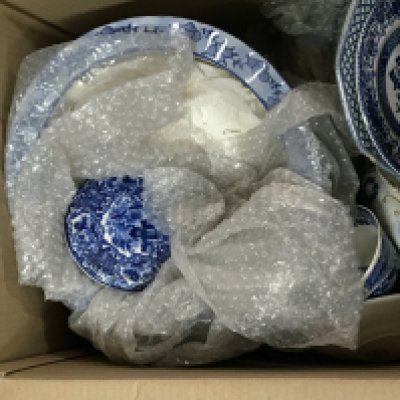 Two boxes containing a quantity of mixed blue and white ceramics.