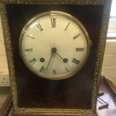 A 19h century French silk suspension table clock the bur and ormaloo cases inset with dial with Roman numerals the movement striking on a bell 43 cm .