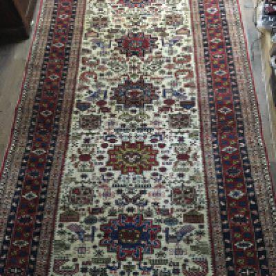 A Pair of Persian hand knotted rugs with a pattern including exotic birds and symbols on an ivory ground with a repeat pattern boarder. 162x270cm approximately. (2)