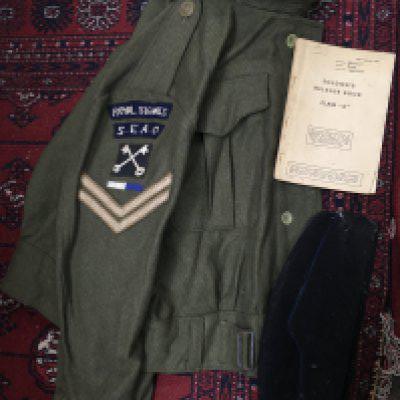 A Royal Signals S.E.A.C jacket, Soldiers Release book and a flat cap