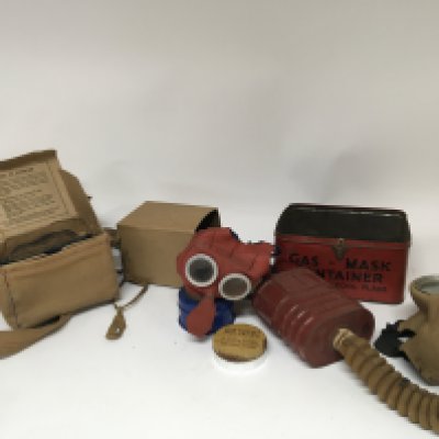 A collection of war issue Gas masks including an unusual child&rsquo;s gas mask in colour of red and blue some in original boxes.