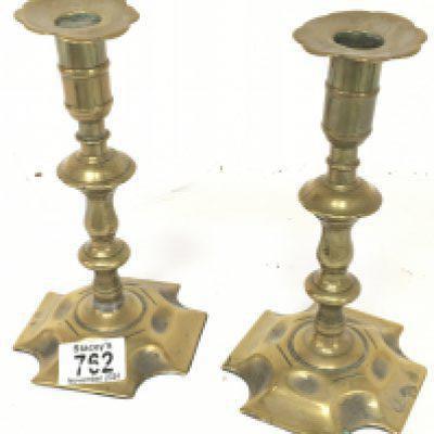 A pair of 18th Century brass candle sticks. With shaped stems and bases with visible seem. Height 20cm. NO RESERVE