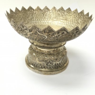 A white metal bowl with oriental markings on the base.