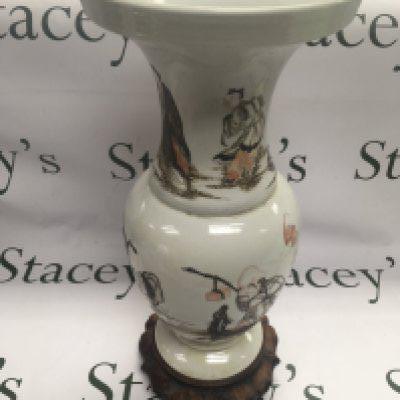 An Oriental vase of baluster form and decorated with figures in a landscape setting and raised on a carved hardwood base, approx total height 45cm. Shipping category D.