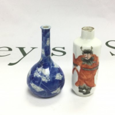 Two small Oriental bud vases, one depicting a warrior and one blue and white example, approx height 8cm. Shipping category D.