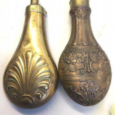 Two 19th century brass and copper powder flasks Repousse chased with a floral pattern. (2)