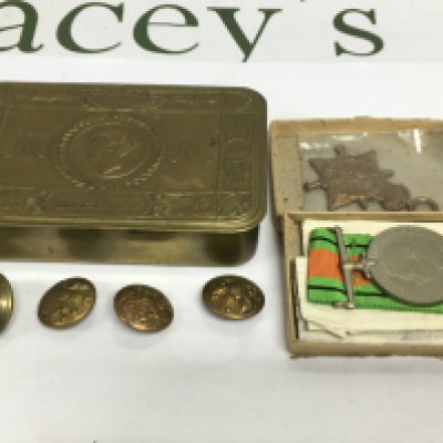 A Princess Mary WW1 tin containing badges and a medal. Shipping category B.