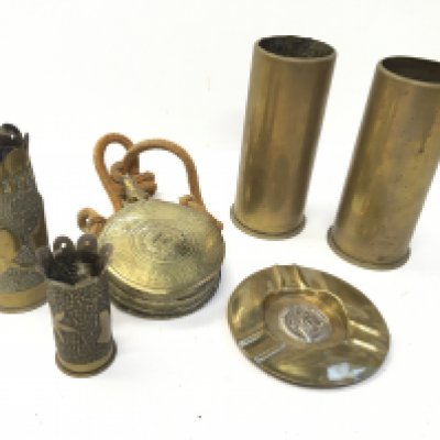 A German Third Reich brass and silver plated ash tray brass trench art shell cases a brass powder flask and other shell cases.