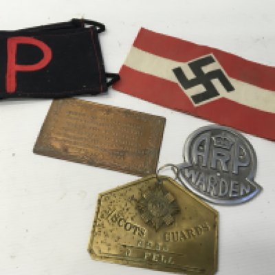 A German Third Reich political armband a cast aluminium ARP warden badge Scots Gaurd badge RP armband and one other plaque.