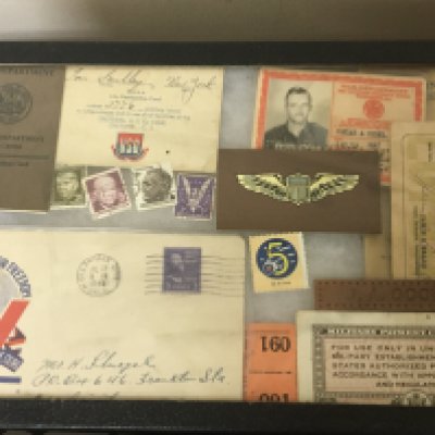 Three display cases containing American War period issue packaging lighters and playing cards.