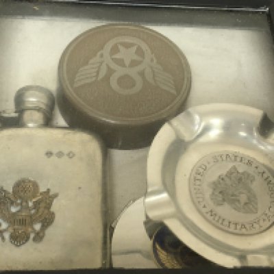 A case containing an American Hip flask desk paperweight ash try lighter Military related.