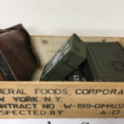 An American II world war food box containing an American field telephone First Aid Kits ammunition tins