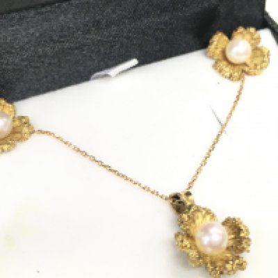 An 18ct gold and pearl necklace and earring set. Postage category A