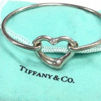 A Tiffany and Co bangle inset with a single diamond stone. Postage category A