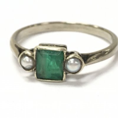 A 9ct white gold ring set with a central emerald and two seed Pearls, ring size J. 1.2g. Postage category A