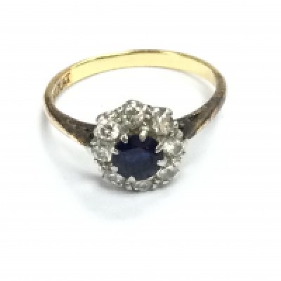 An 18ct gold and platinum ring set with central sapphire flanked by diamonds. Size M and 3.16g