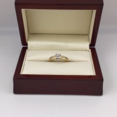 An 18ct gold diamond set ring with a central setting and diamonds set on both shoulder. Approx weight 3.73 grams, approx size O.