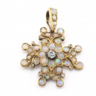 An Edwardian high carat opal star pendant set with central diamond. Approximately 0.35/0.40 ct.Postage B