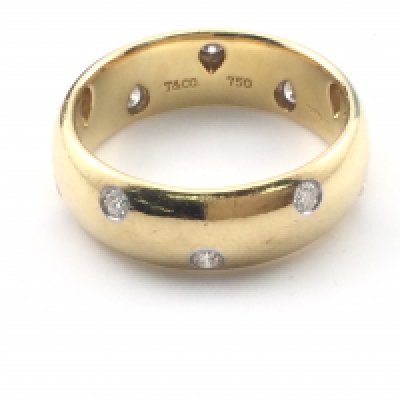 An 18k gold Tiffany and Co gents wedding ring set with diamonds. Size Y and 14.48g. Comes with original ring box and outer box.